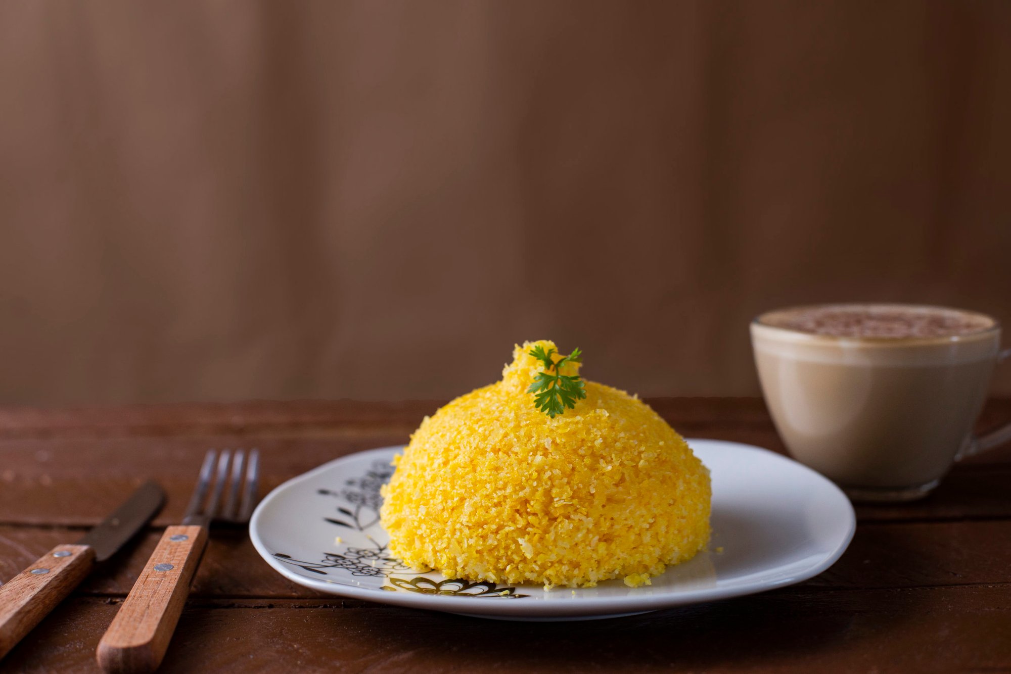 cuscuz-with-cheese-typical-northeastern-food-white-plate-wooden-table